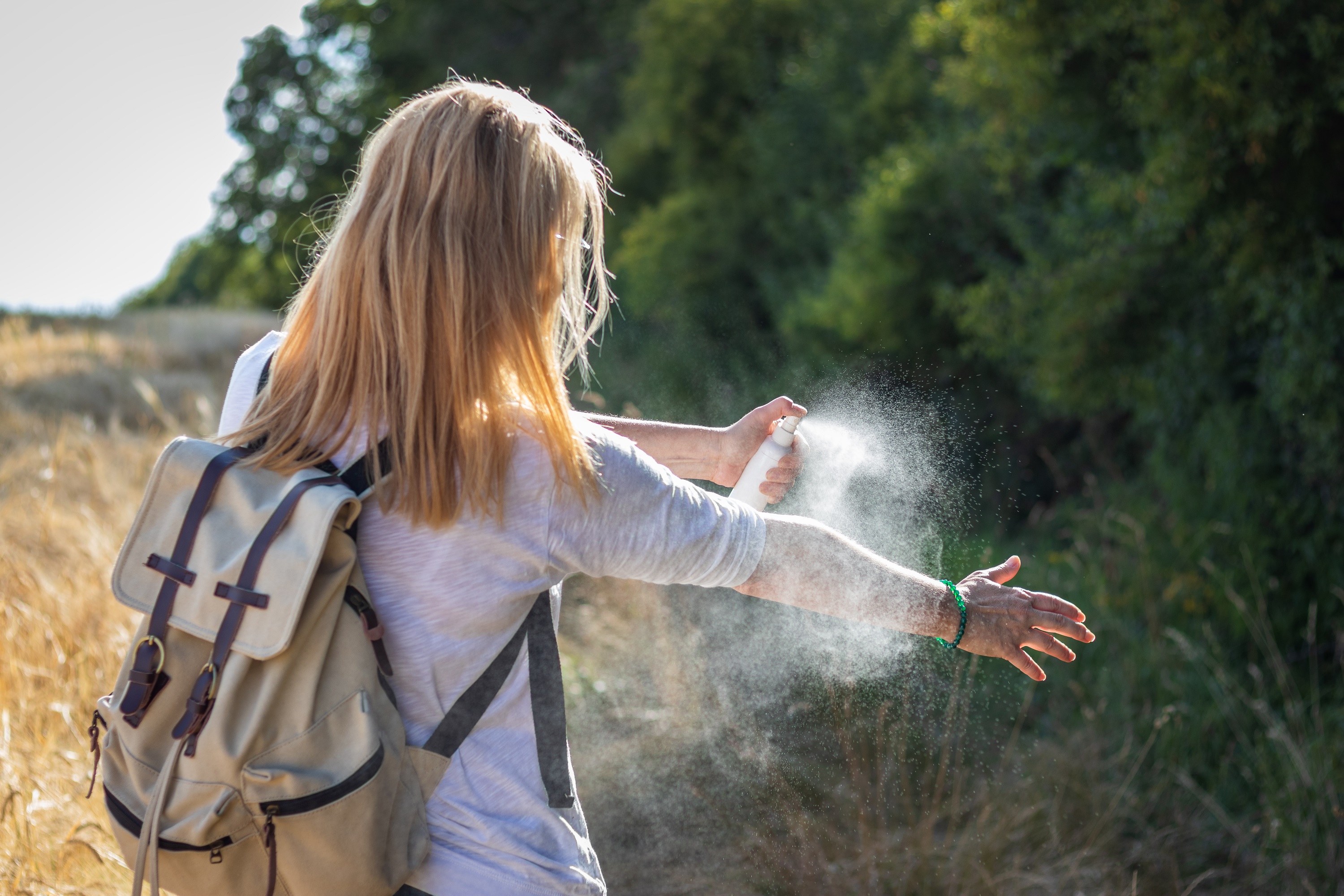 person spraying bug spray