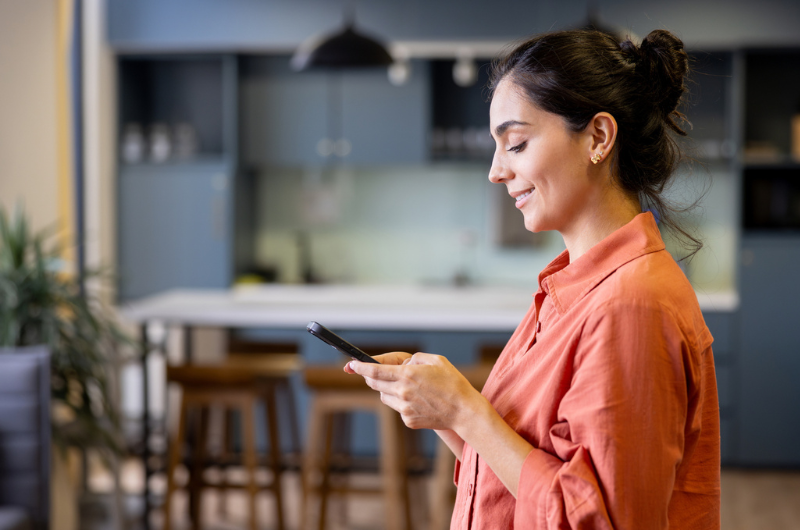 Beautiful Latin American businesswoman texting on her cell phone.