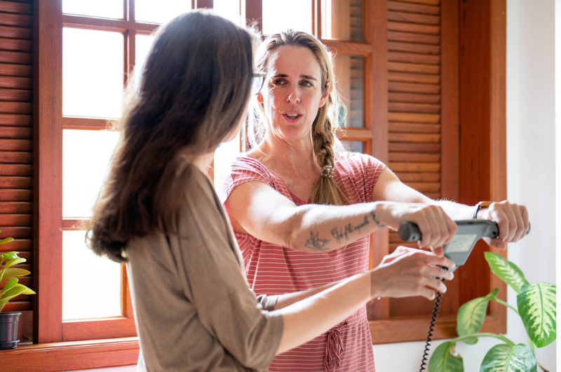 Female nutritionist speaking with a client using a body composition monitor.