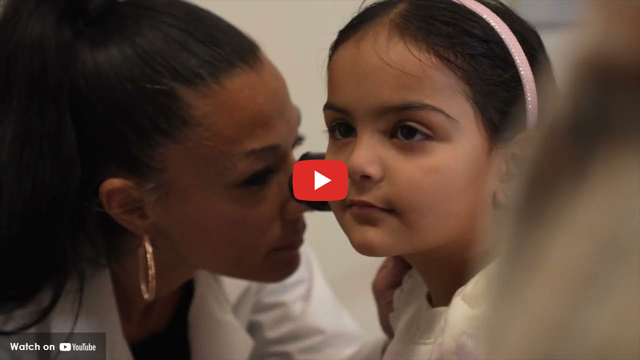 Clinician examining a child’s ear