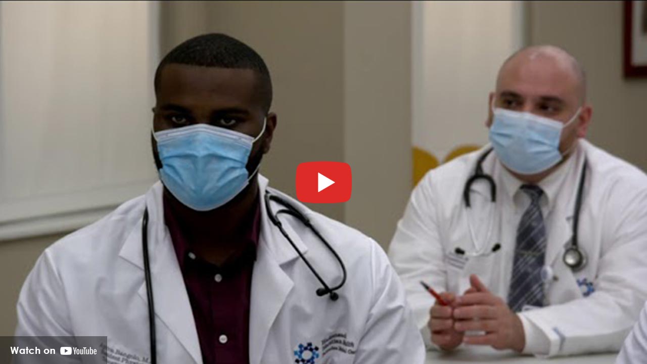 two doctors with face masks on looking forward