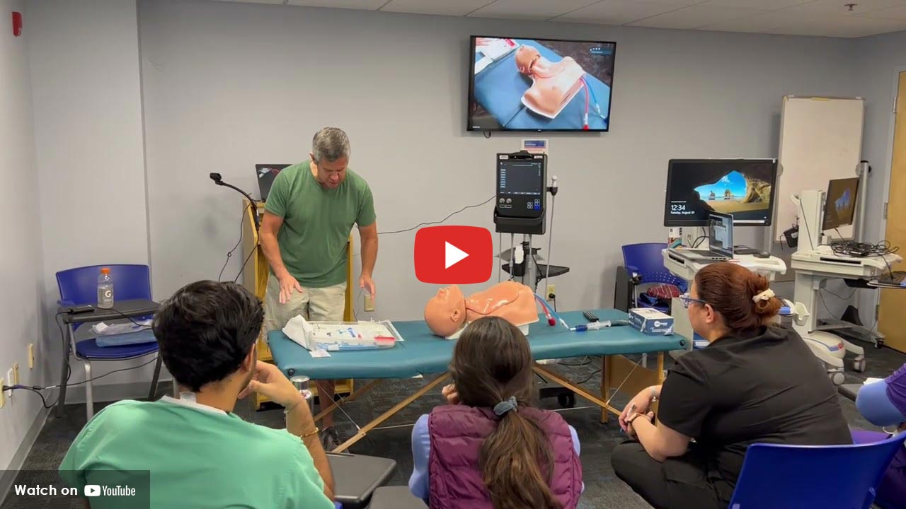A man demonstrating something medical related in front of a classroom of young kids